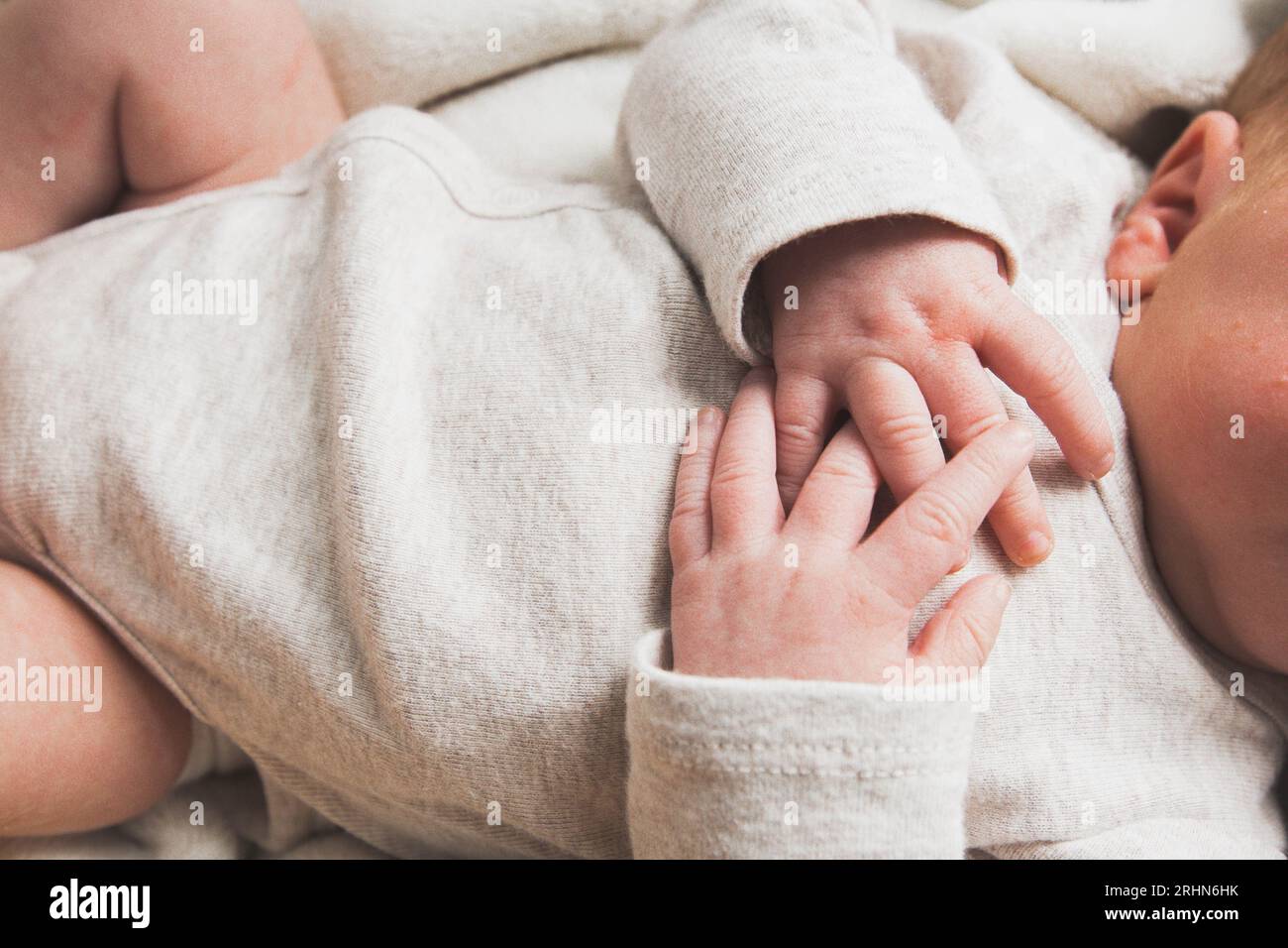 Neugeborene Hände auf der Brust Stockfoto