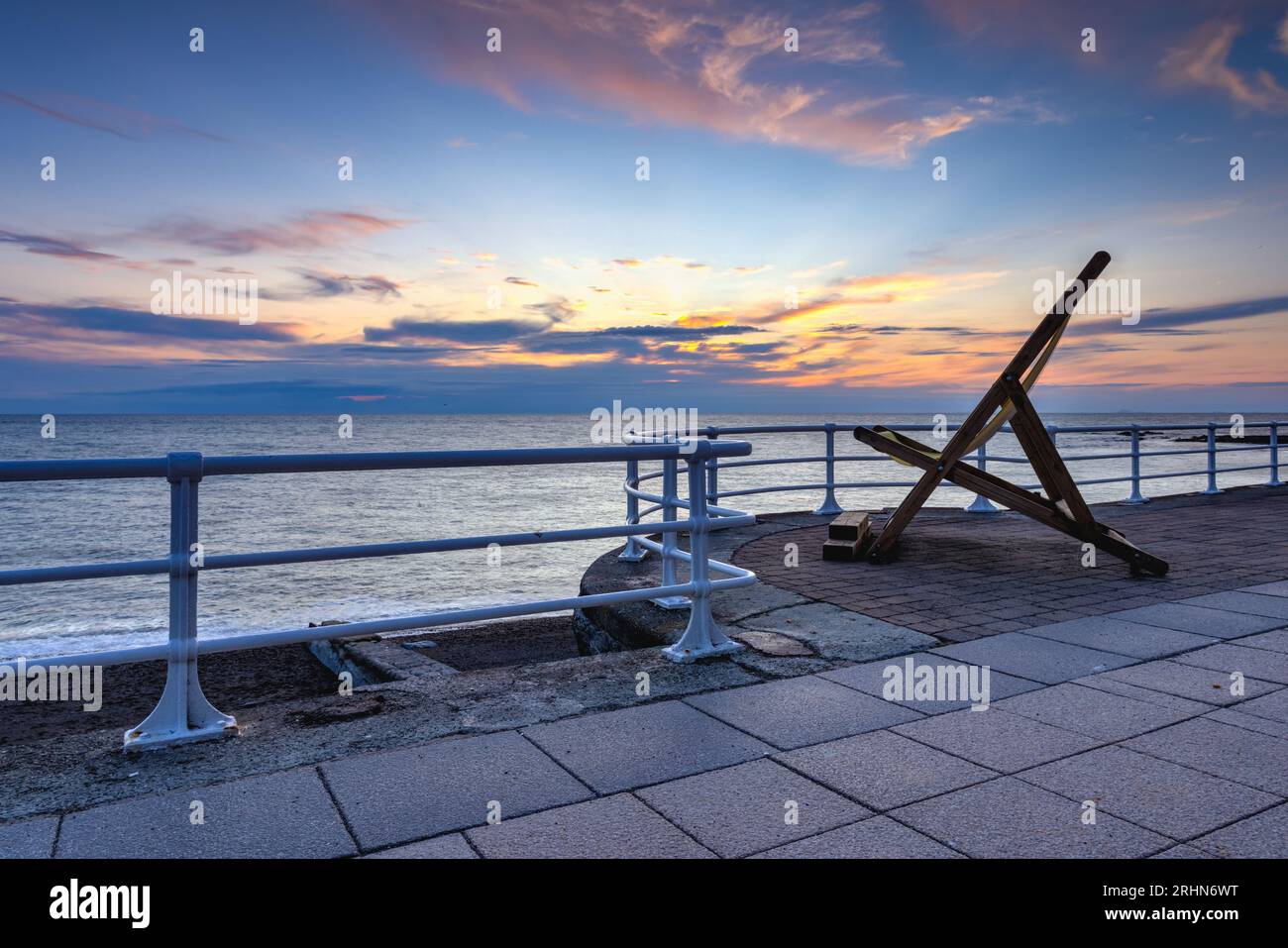 Große Sonnenliege auf der langen Promenade in Aberystwyth bei Sonnenuntergang Stockfoto