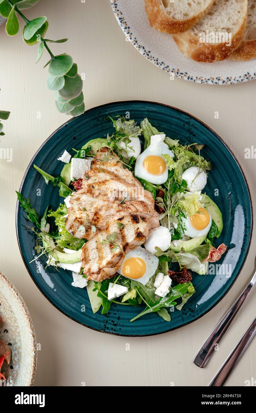 Warmer Salat mit gegrilltem Hähnchen und Ei. Restaurantmenü Stockfoto