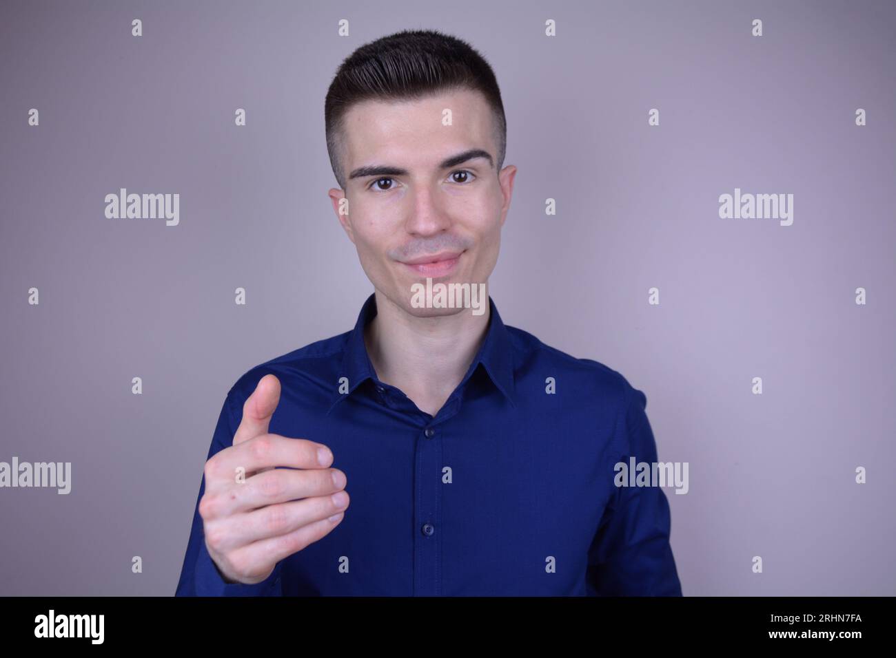 Eleganter und schöner junger kaukasischer Mann mit unsichtbarem Objekt auf isoliertem Hintergrund Stockfoto