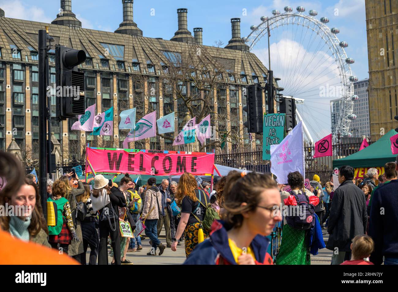 LONDON - 22. April 2023: Unifying Visuals: Extinction Rebellion Demonstranten, Flaggen hoch, stehen vor dem legendären London Eye und symbolisieren den Ruf nach Stockfoto