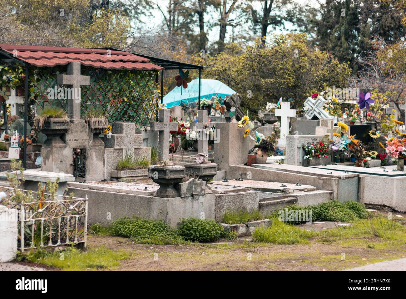 Gräber, Kreuze und Tempel auf einem Freiluftweg auf einem Friedhof Stockfoto