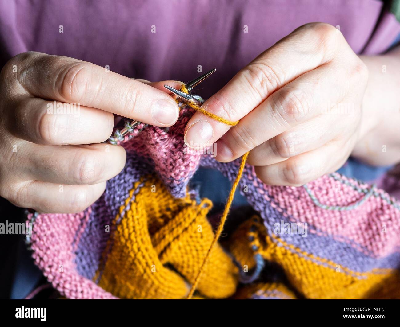 Strickpullover aus Wollgarn auf Stahlstricknadeln aus Nahaufnahme Stockfoto