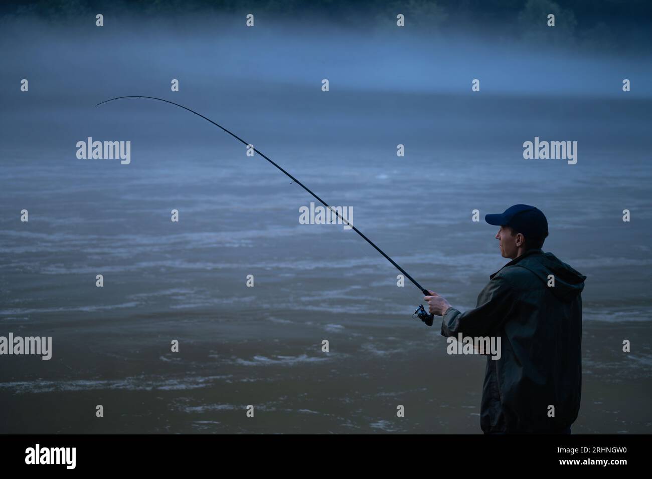 Mann, der abends auf dem Bergfluss angeln kann. Hochwertige Fotos Stockfoto
