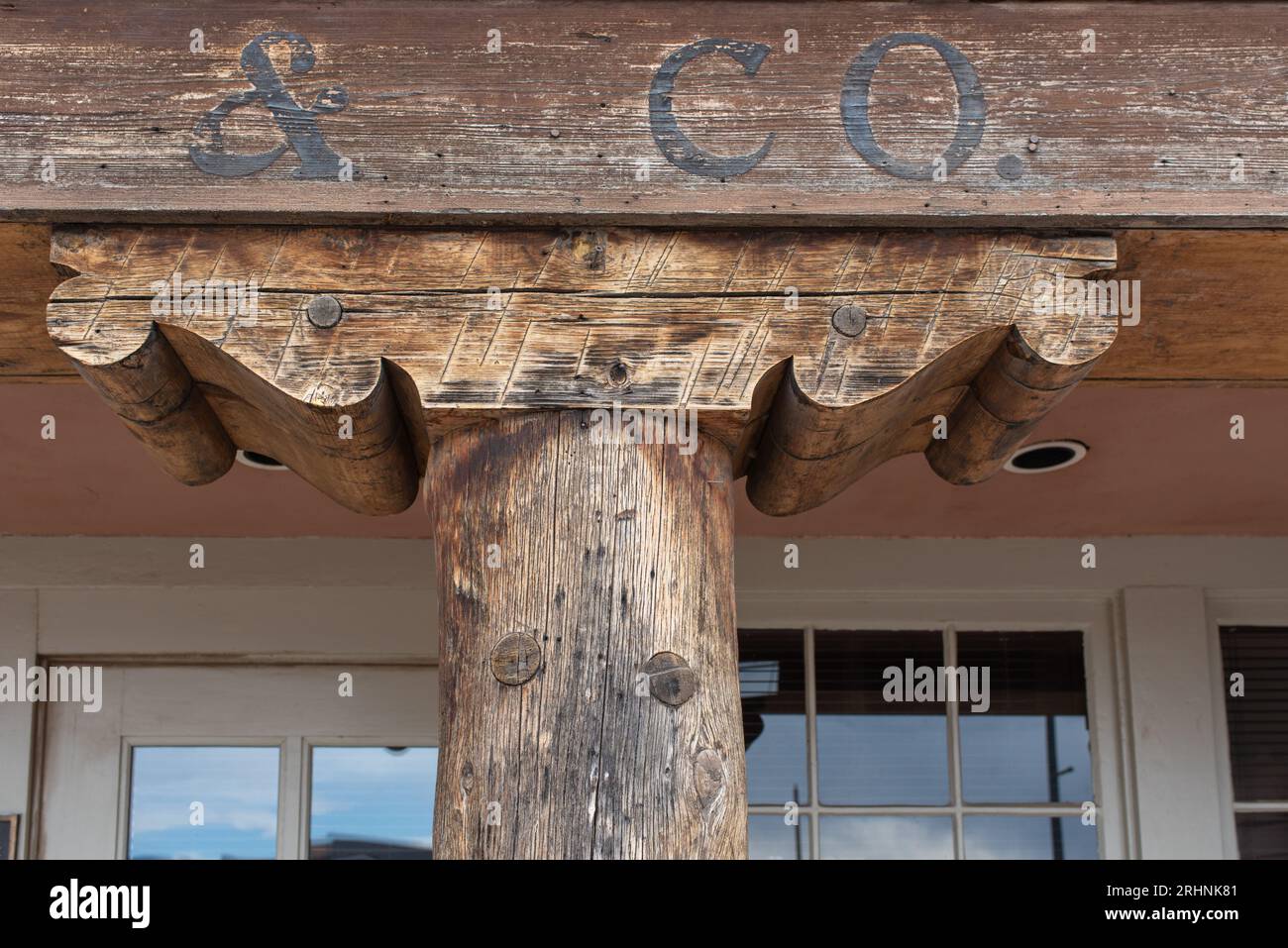 Ein alter Korbel, wahrscheinlich handgeschnitten, trägt dazu bei, das Gewicht eines schweren Balkens, der traditionellen Architektur in Santa Fe, New Mexico, USA, zu verteilen. Stockfoto