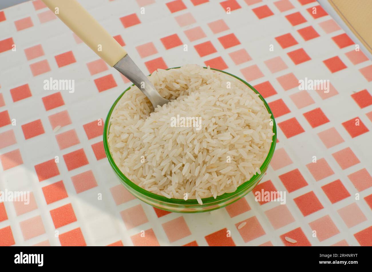 Nahaufnahme einer mit Reiskörnern gefüllten Schüssel, die ein Gefühl von Einfachheit und Komfort vermittelt. Stockfoto