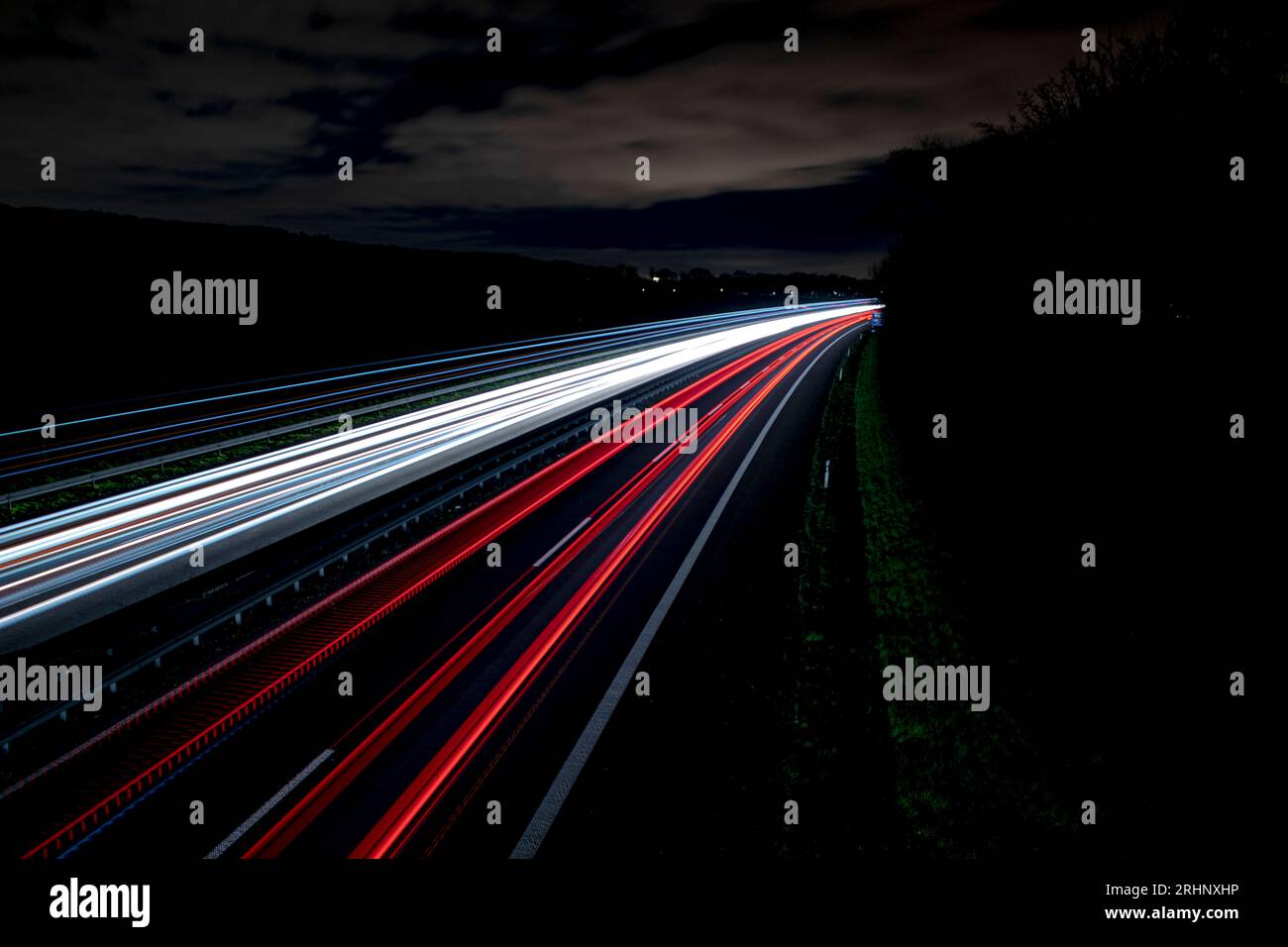 Langzeitbelichtung auf einer Autobahn in deutschland bei Nacht, Lichtwege kalte Farben Stockfoto