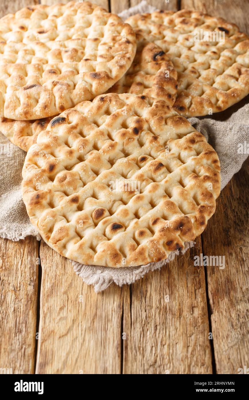 Frisch gebackenes griechisches Fladenbrot auf dem Holztisch. Vertikal Stockfoto