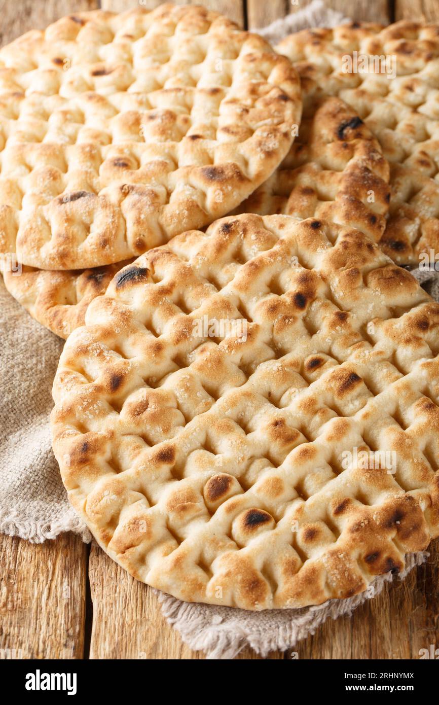 Griechisch frisch gebackenes Fladenbrot aus der Nähe auf einem Holztisch. Vertikal Stockfoto