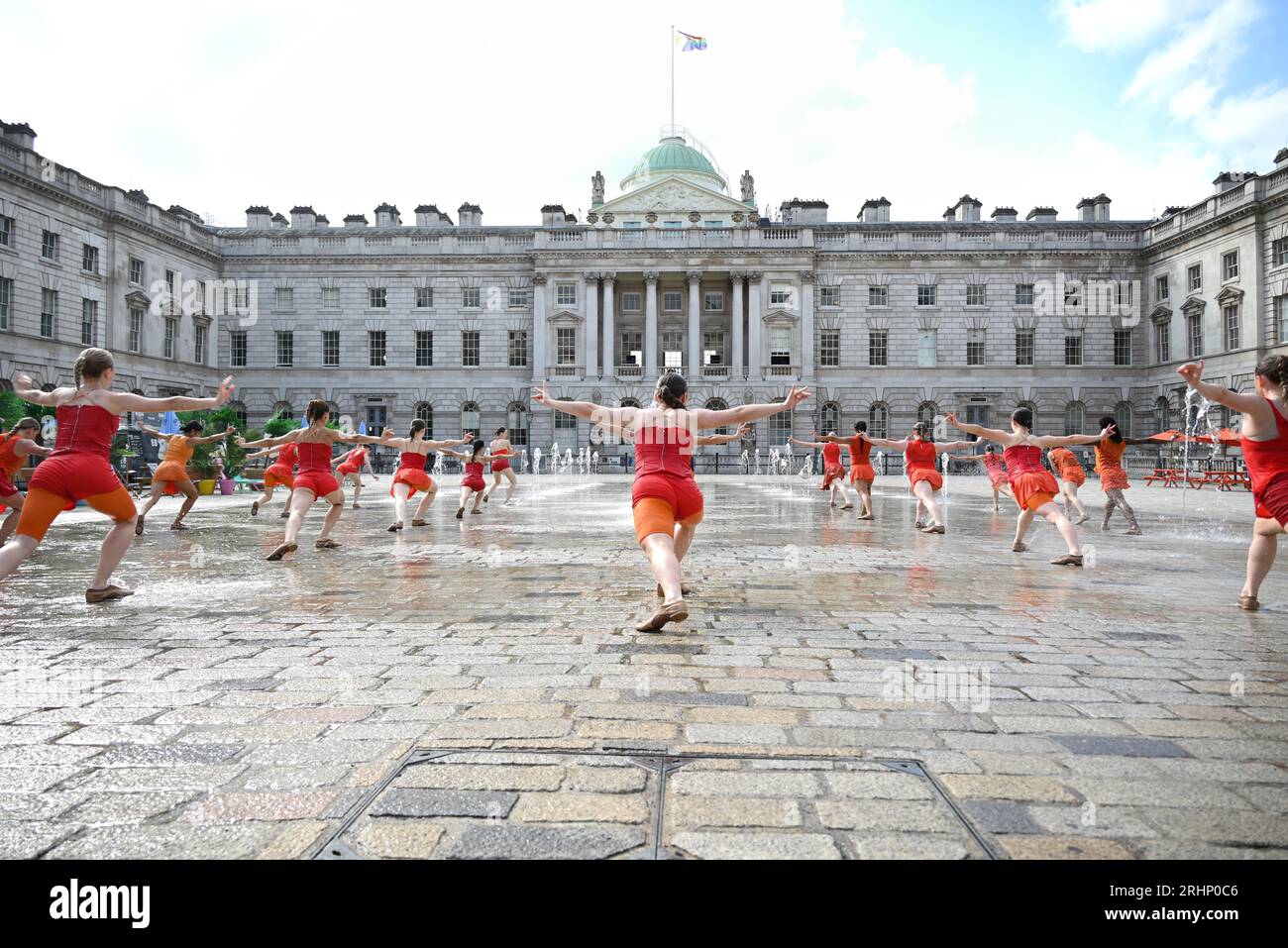 22 Tänzerinnen in leuchtend orangen Kostümen, die von Ursula Bombshell entworfen wurden und in den Springbrunnen des Somerset House in einer Kostümprobe für Shobana Jeyasinghs Kontrapunkt tanzen. Jeyasinghs fließende Choreographie, vollgepackt mit Wiederholungen und Unisono, bewegt sich in, um und durch die sich ständig verändernden auf- und Abstürze des Wassers in dieser aufregenden zehnminütigen Tanzarbeit Stockfoto