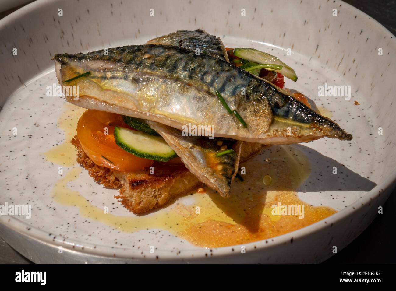 Vorbereitetes Gericht aus gebratenen Makrelenfilets mit Tomatenzuchtzuchtkerzen und Samphir Stockfoto