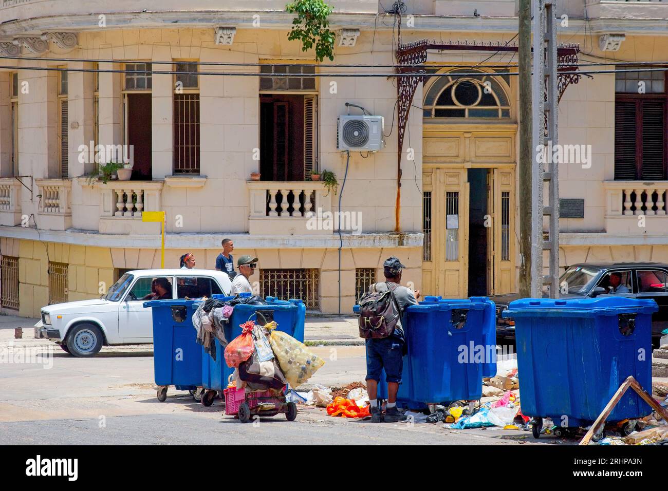 Havanna, Kuba - 27. Juli 2023: Menschen mit einem rustikalen Wagen suchen in den großen Straßenkorbbehältern Stockfoto
