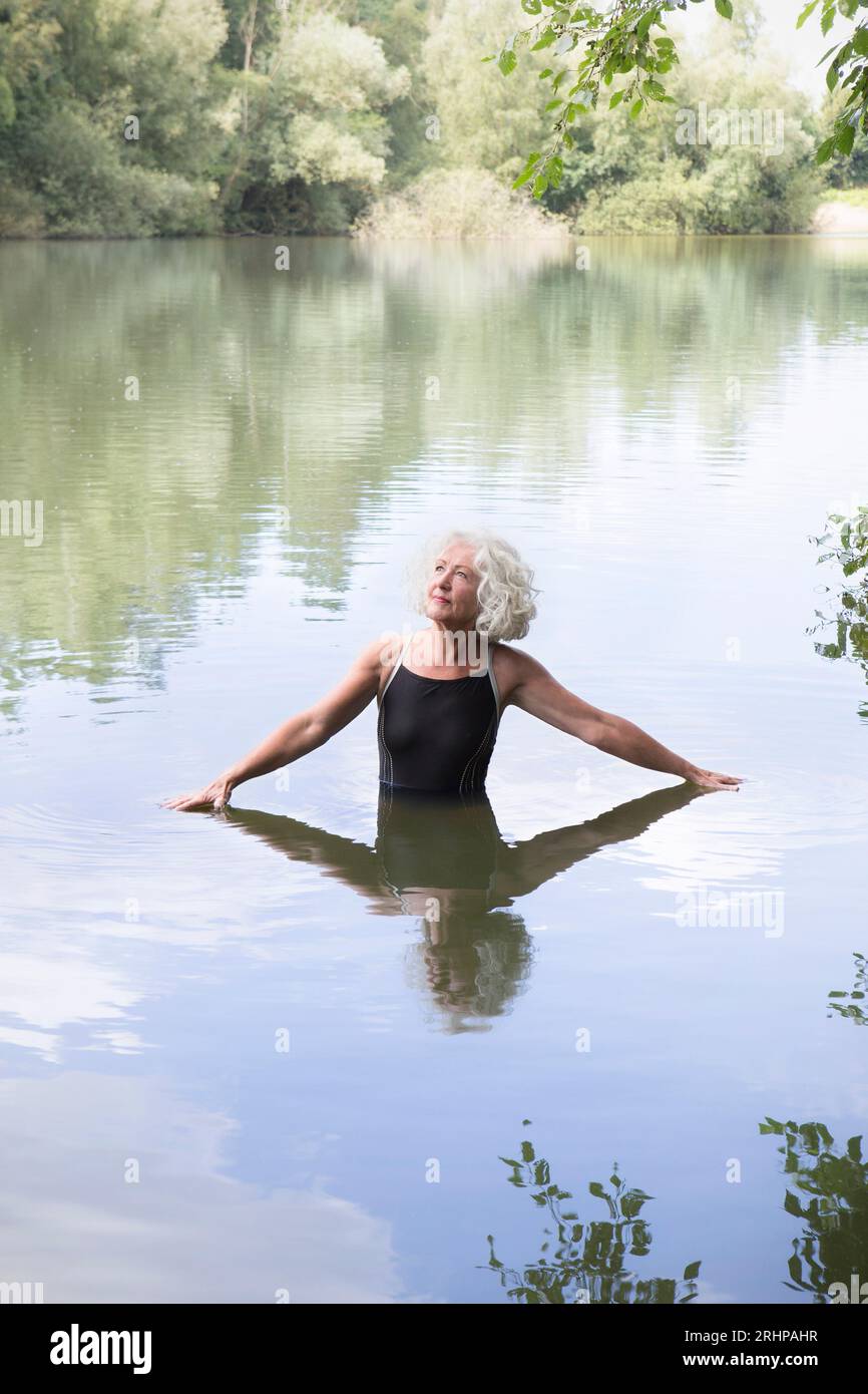 Ältere Frau, die im See badet Stockfoto