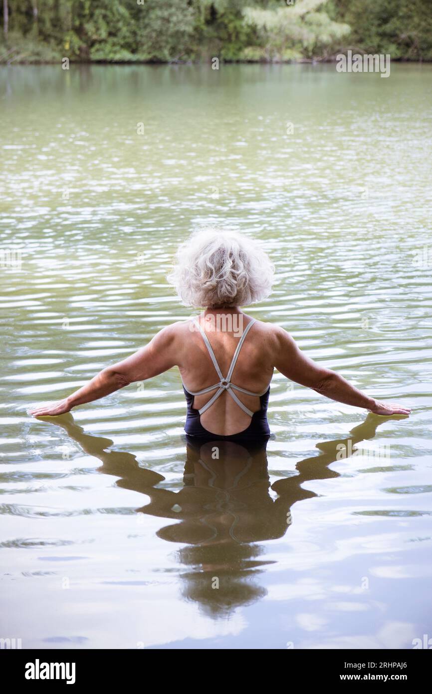 Ältere Frau, die im See badet Stockfoto