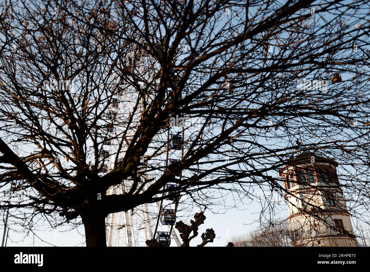 Düsseldorf 07.12.2021 das Riesenrad auf dem Burgplatz in Düsseldorf steht vor einer Litfaßsäule mit Werbung der Privatbrauerei Füchschen, auf der ein Paar ( Mann und Frau ) aus Plastik stehen. Foto: Norbert Schmidt, Düsseldorf Stockfoto