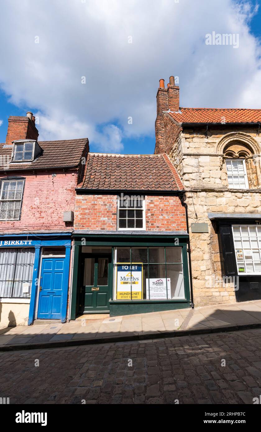 Kleines Gebäude zwischen zwei größeren Gebäuden, Steilhang, Lincoln City, Lincolnshire, England, UK Stockfoto