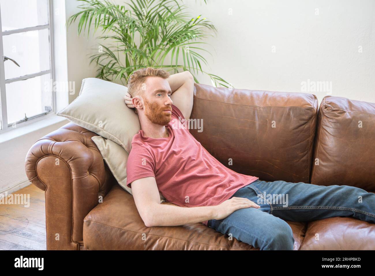 Junger Mann auf sofa Stockfoto