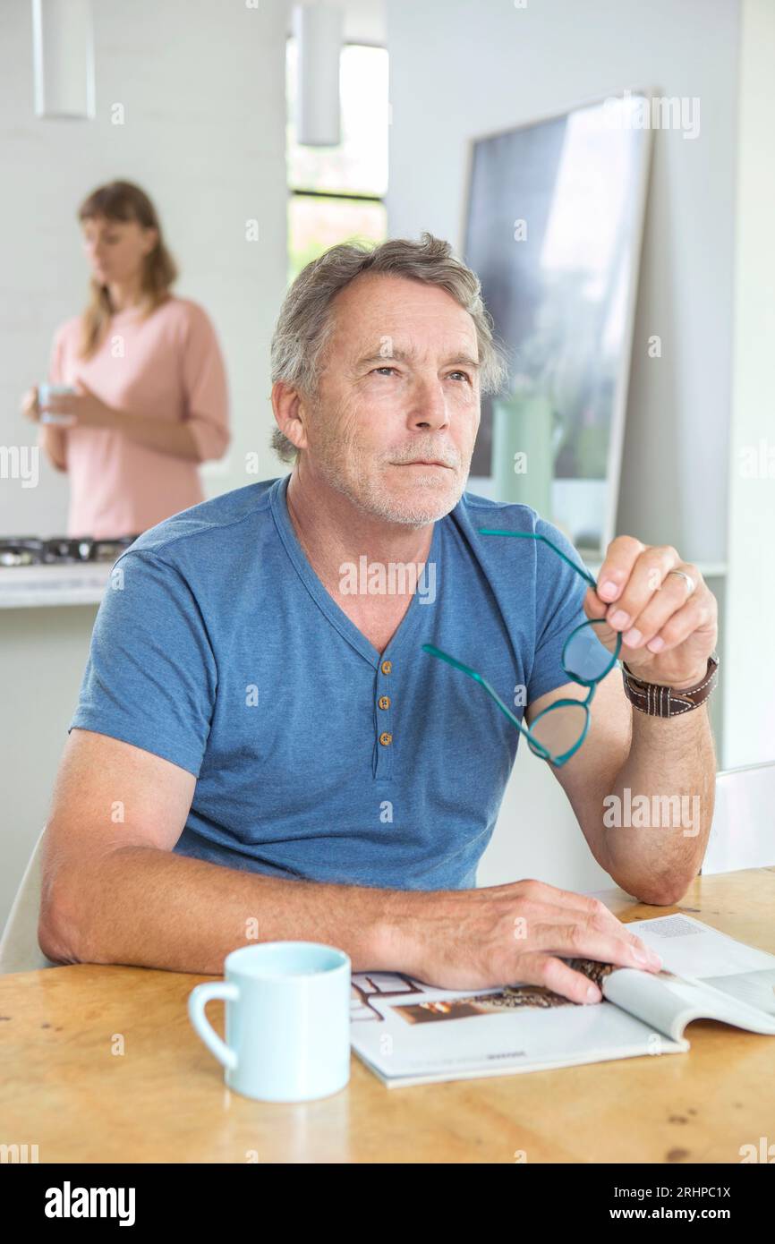 Älterer Mann am Tisch Stockfoto