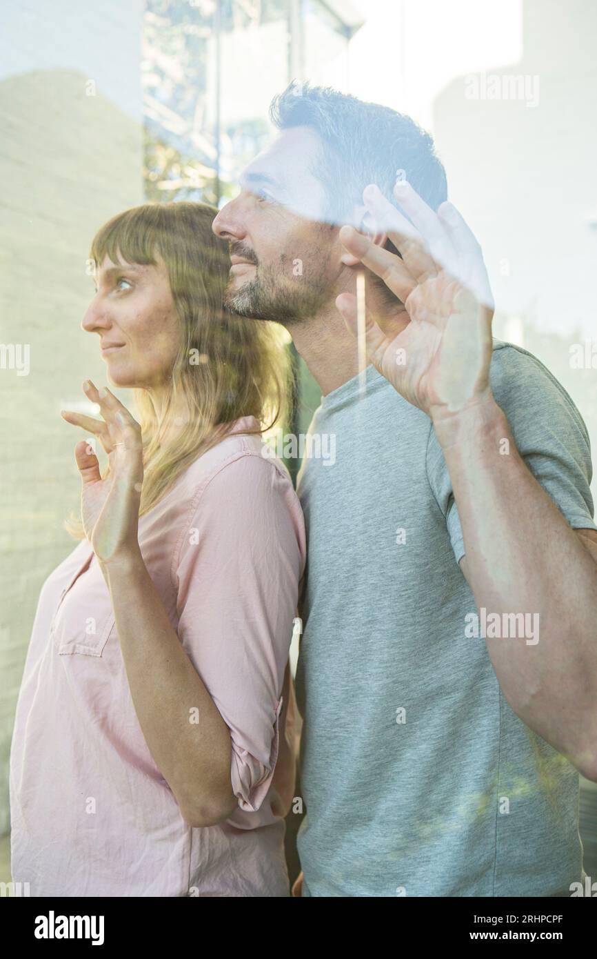 Das Paar sieht nachdenklich aus dem Fenster Stockfoto