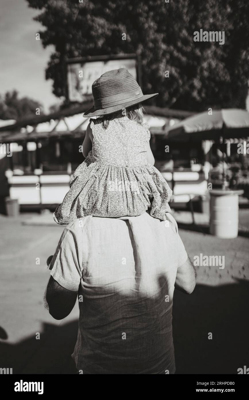 Der Großvater trägt die Enkelin auf der Schulter über das Messegelände Stockfoto