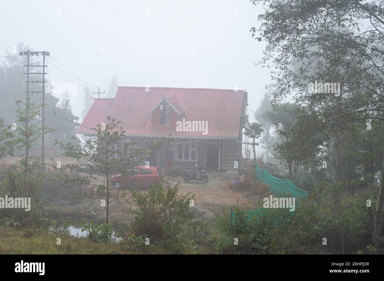 Ein Berghaus an einem nebligen Morgen. Nebelhügel und Wald in der Winterlandschaft im Dezember. Stockfoto