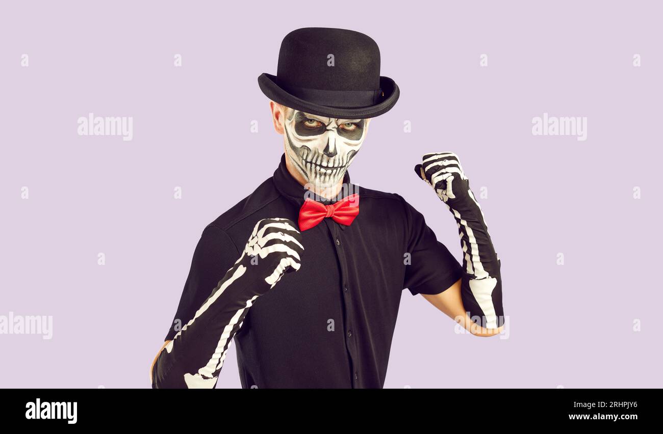 Der Mann im gruseligen Skelett-Halloween-Kostüm ballt seine Fäuste und ist bereit zu kämpfen Stockfoto