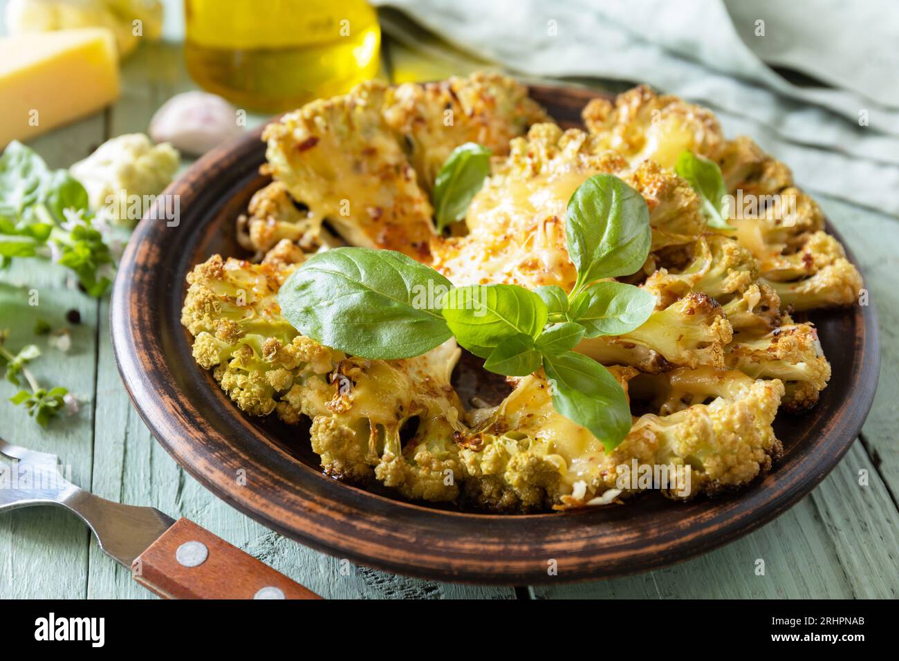 Vegetarische Bio-Gerichte. Gebackene Blumenkohlsteaks mit Kräutern und Gewürzen auf einem Holztisch. Gesunde Ernährung, pflanzliches Fleischersatzkonzept. Stockfoto