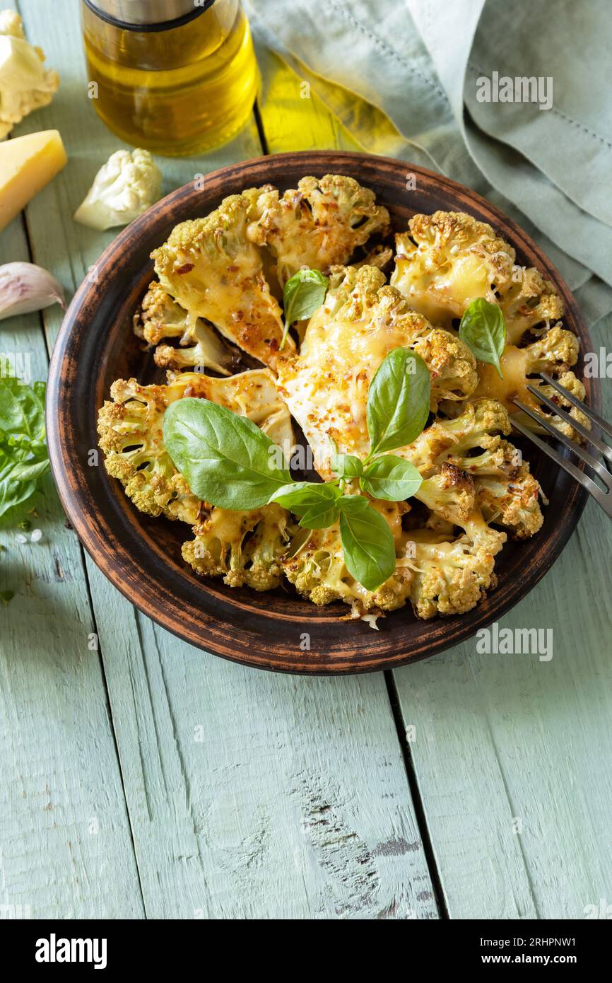 Gesunde Ernährung, pflanzliches Fleischersatzkonzept. Vegetarische Bio-Lebensmittel. Gebackene Blumenkohlsteaks mit Kräutern und Gewürzen auf einem Holztisch. Copy sp Stockfoto