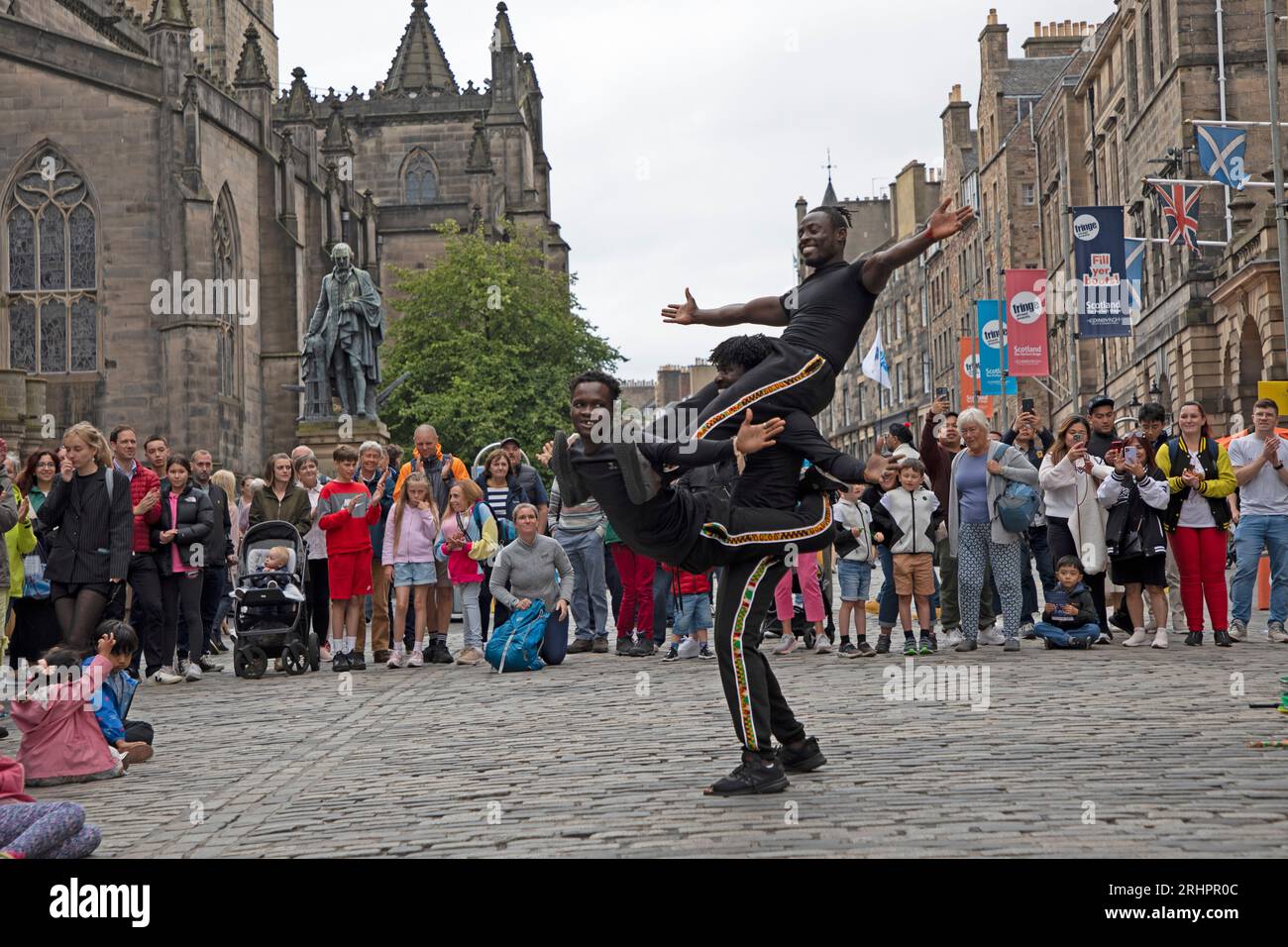 Royal Mile, Edinburgh Fringe, Schottland, Großbritannien. August 2023. Am Ende der zweiten Woche des Edinburgh Festival Fringe waren die Massen auf der Suche nach Unterhaltung, aber nicht wie in den Jahren vor covid. Im Bild: Fanti-Akrobaten zeigen auf der High Street ihre Fähigkeiten. Quelle: Archwhite/Alamy Live News. Stockfoto