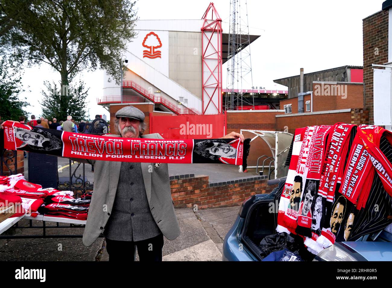 Ein Straßenverkäufer hält einen Schal in Erinnerung an den ehemaligen Nottingham Forest-Spieler Trevor Francis vor dem Spiel der Premier League im City Ground in Nottingham. Bilddatum: Freitag, 18. August 2023. Stockfoto