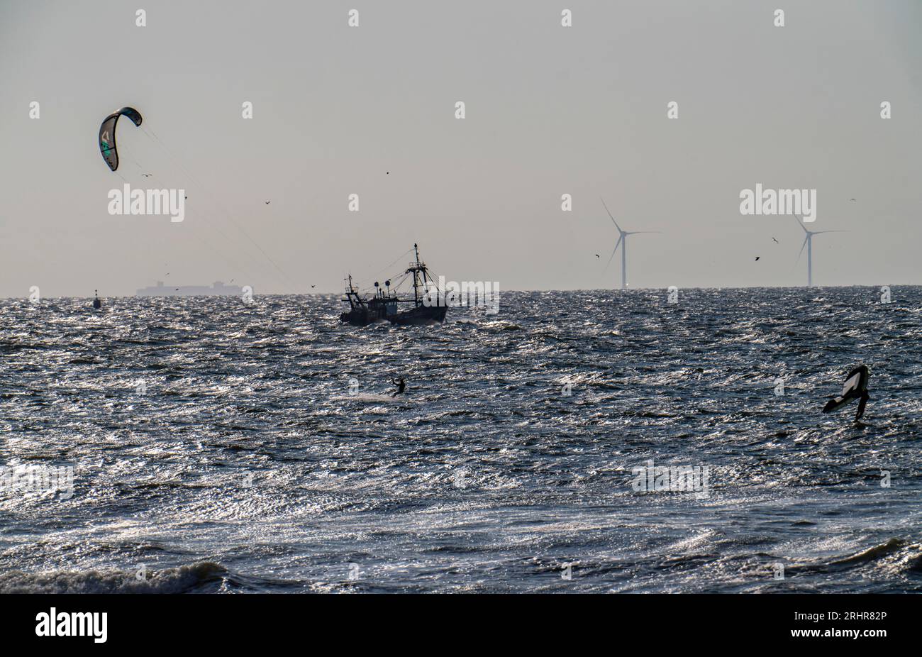 Kitesurfer und Garnelenboote vor der Küste von Scheveningen, den Haag, Niederlande Stockfoto
