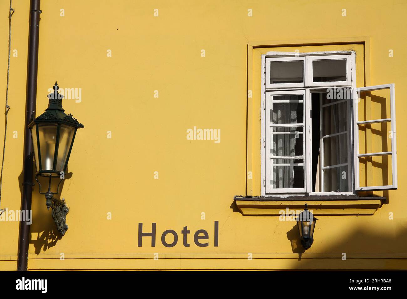 Hotelfenster mit gelb gestrichener Wand und weißem Holzrahmen und Straßenlaterne in Prag, Tschechische Republik Stockfoto