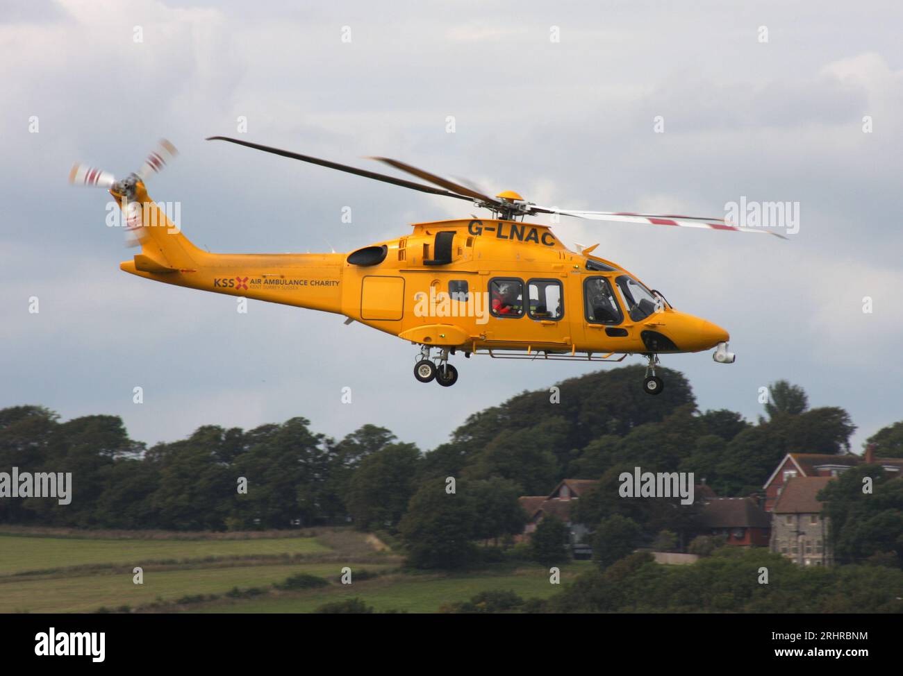 Ein AW-169-Rettungswagen des Kent Surrey Sussex Trust verlässt den Brighton City Airport mit einem Cessna 510 Citation Business Jet im Vordergrund. Stockfoto