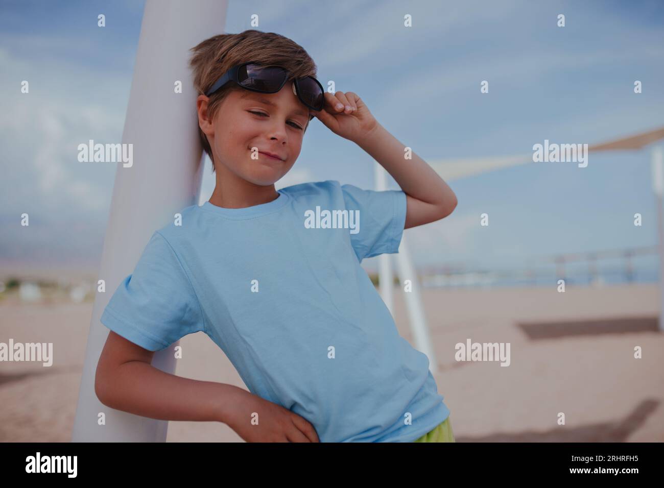 Porträt eines gutaussehenden Jungen mit Sonnenbrille am Strand Stockfoto