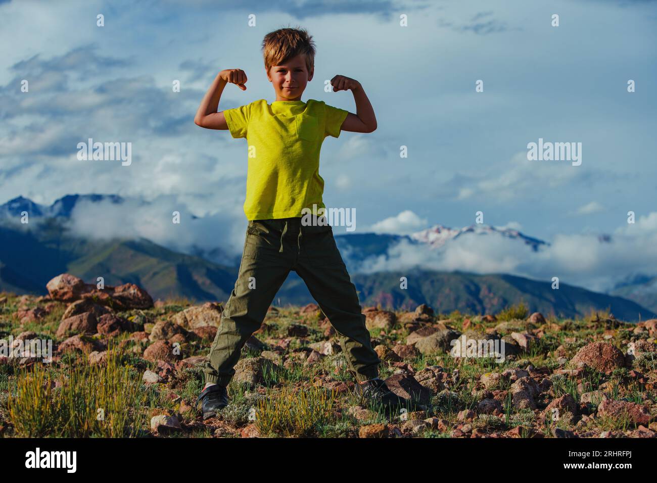 Glücklicher starker Junge im Sommer im Hintergrund der Berge Stockfoto