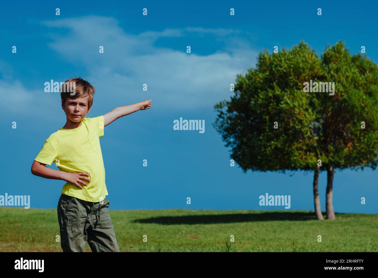 Boy zeigt auf den Baum an einem sonnigen Tag, Ökologiekonzept Stockfoto
