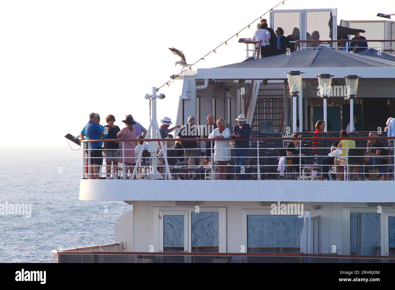 Kreuzfahrtpassagiere in gemütlicher Partystimmung, während ihr Schiff der Vista-Klasse „Oosterdam“ ihre Anlegestellen verlässt Civitavecchia, Italien, April 2023. Stockfoto