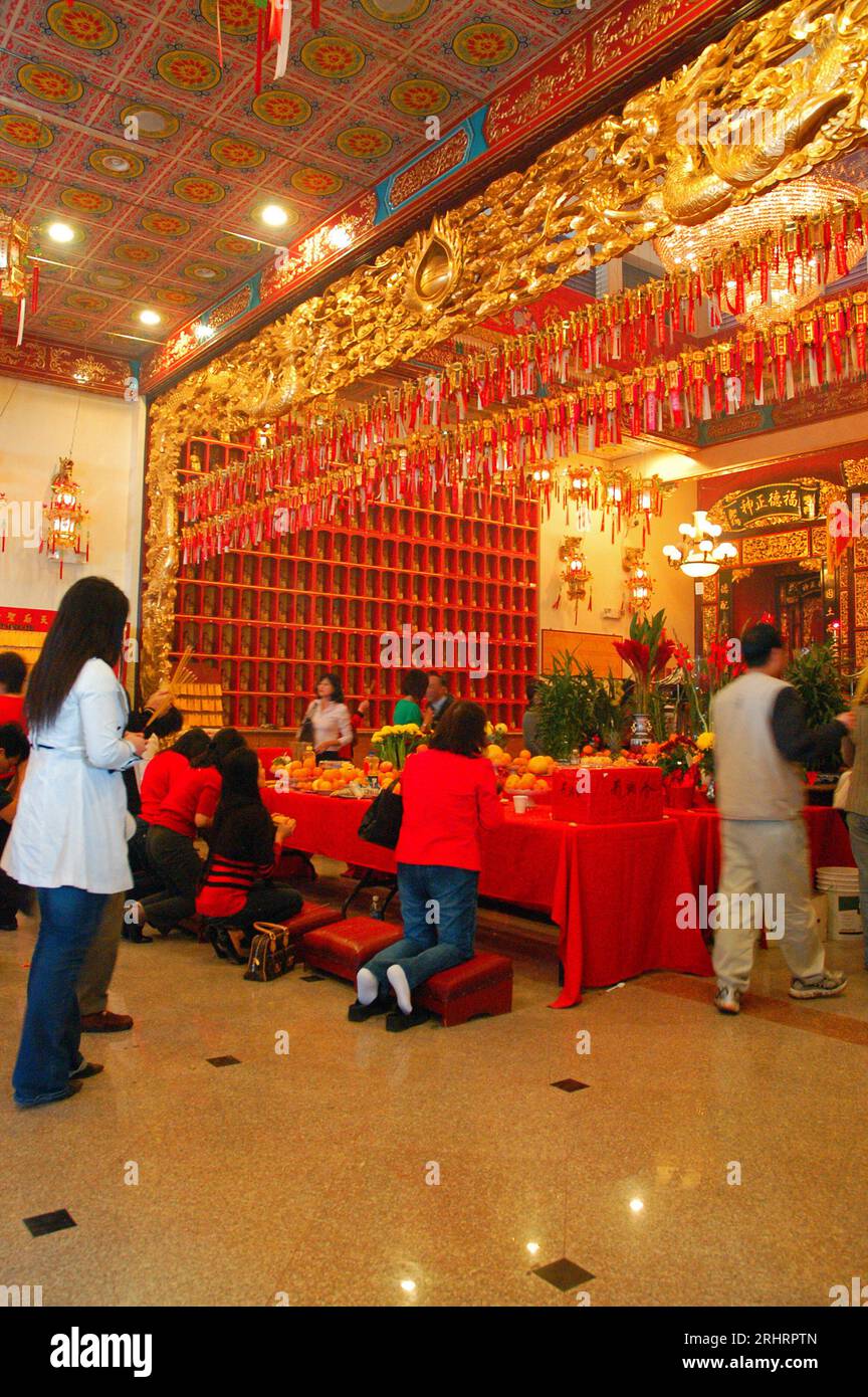 Gläubige versammeln sich in einem buddhistischen Tempel in Los Angeles, um das Mondneujahr zu feiern und beten und schenken am Altar Stockfoto