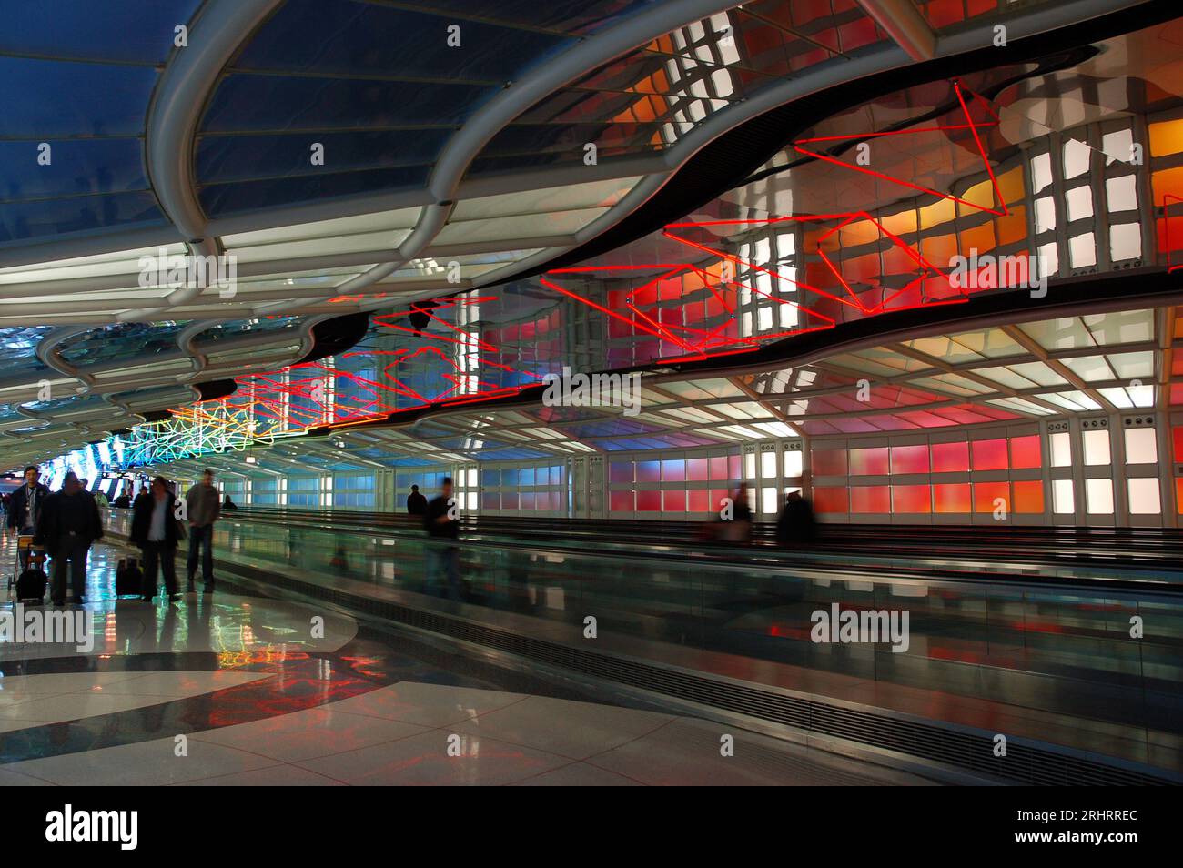 Reisende spazieren durch das Sky's The Limit, ein farbenfrohes und leuchtendes Kunstwerk, das zwischen den Terminals des O'Hare International Airport in Chicago installiert ist Stockfoto