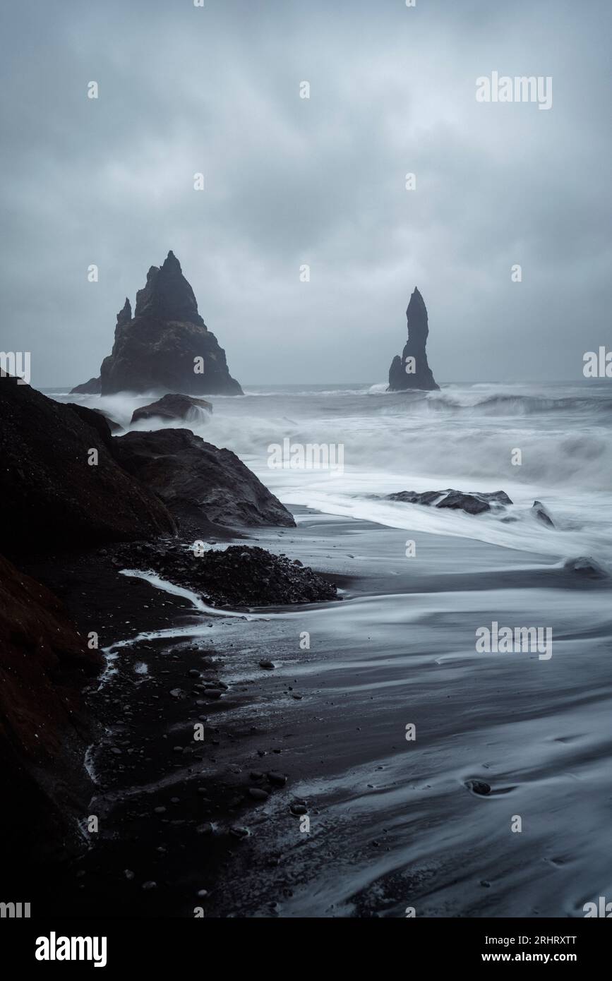 Black Sand Beach in Island. Weiße Wellen stürzen auf die inky isländische Küste und erzeugen holographische Muster auf dem tiefschwarzen Sand Stockfoto