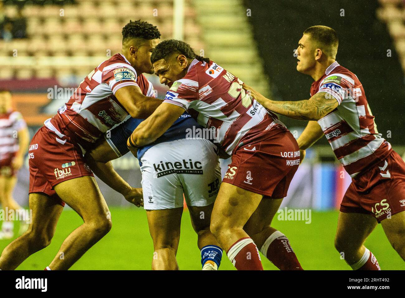 Kai Pearce-Paul und Patrick Mago kämpfen gegen Chris Satae vom FC Hull während des Spiels der Betfred Super League zwischen Wigan Warriors und Hull Football Club im DW Stadium, Wigan am Freitag, den 18. August 2023. (Foto: Ian Charles | MI News) Credit: MI News & Sport /Alamy Live News Stockfoto