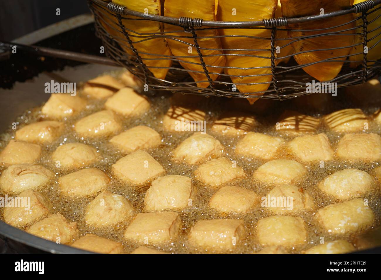 Tofu wird derzeit in sehr heißem Öl gebraten, und darüber hinaus gibt es auch einen Korb mit anderen Pommes Frites. Street Food-Anbieter. Stockfoto