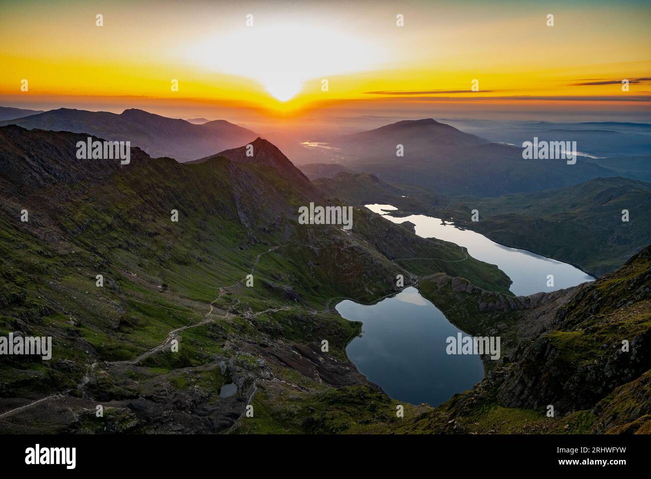 Snowdonia. Der Sonnenaufgang vom Gipfel des Mount Snowdon, Yr Wyddfa, mit Blick nach Osten in Richtung Glaslyn See (nächste Kamera) und Llyn Llydaw dahinter. Schnee Stockfoto