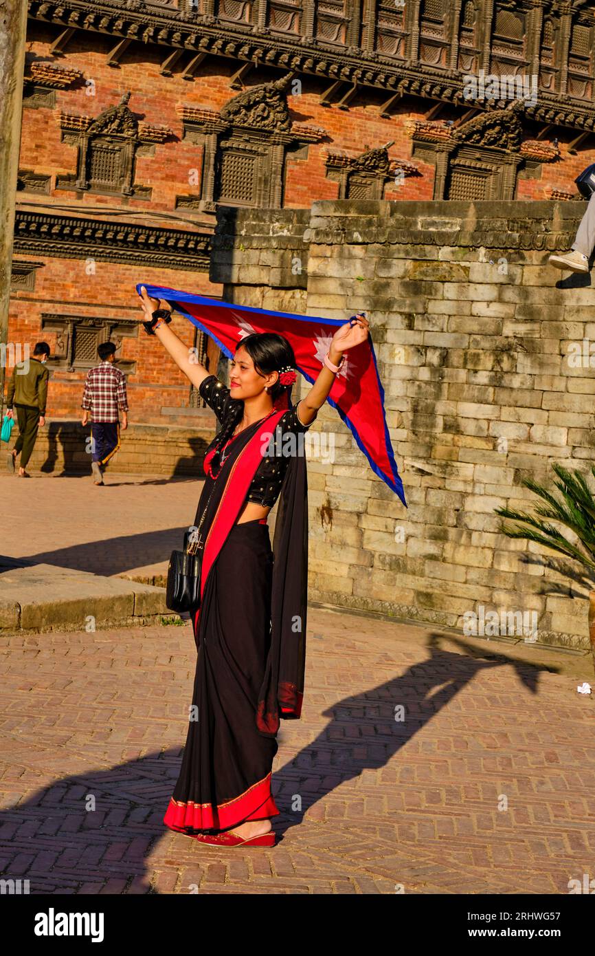 Nepal, Kathmandu-Tal, UNESCO-Weltkulturerbe, Stadt Bhaktapur, Durbar-Platz, junge newar-Frau mit der Flagge Nepals Stockfoto