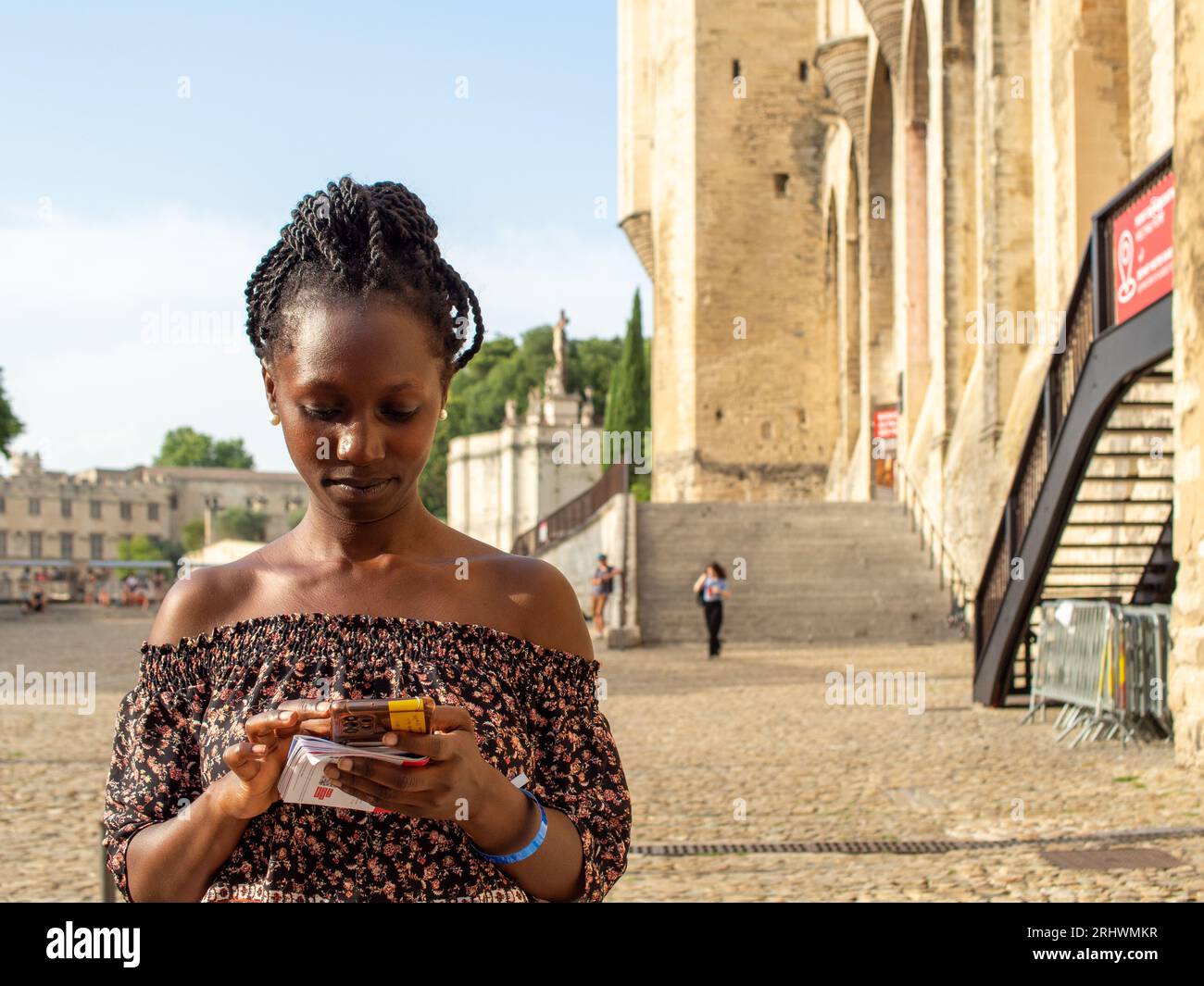 Junge, schöne Frau, die in einem historischen französischen Ort Avignon tippt Stockfoto