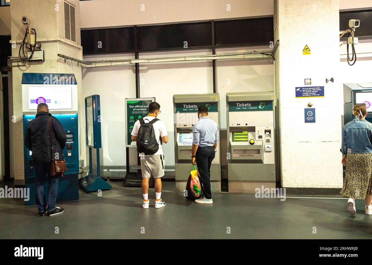 Euston, London, Großbritannien. August 2023. Passagiere, die Bahnfahrkarten an Automaten am Bahnhof Euston in London kaufen. Die RMT-Gewerkschaft hat Streikaktionen angekündigt, die mehrere Zugverkehrsunternehmen betreffen sollen. Diese finden am Samstag, den 26. August und Samstag, den 2. September 2023 statt. Die ASLEF-Gewerkschaft hat auch die Streikaktion für Freitag, den 1. September, sowie die „Aktion kurz vor einem Streik“ am Samstag, den 2. September (am selben Tag wie die vollständige Streikaktion der RMT-Gewerkschaft) angekündigt. Eine Reihe von Eisenbahnunternehmen wird von den Arbeitskampfmaßnahmen betroffen sein. Quelle: Maureen McLean/Alamy Live News Stockfoto