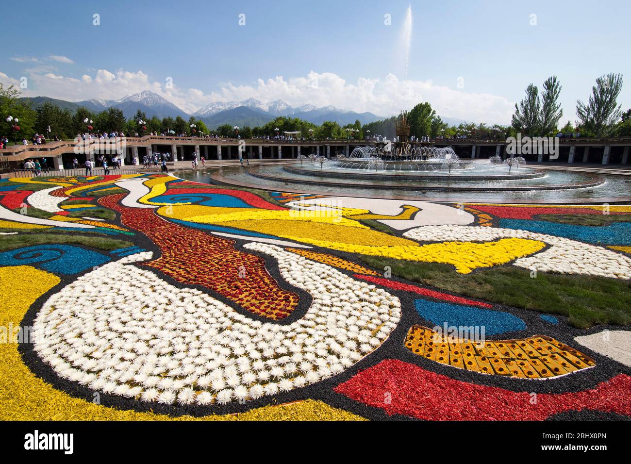 Almaty/Kasachstan - Mai 2014 Bunte Zeichnung aus bunten Blumen im First President Park mit schneebedeckten Alatau Bergen im Hintergrund Stockfoto