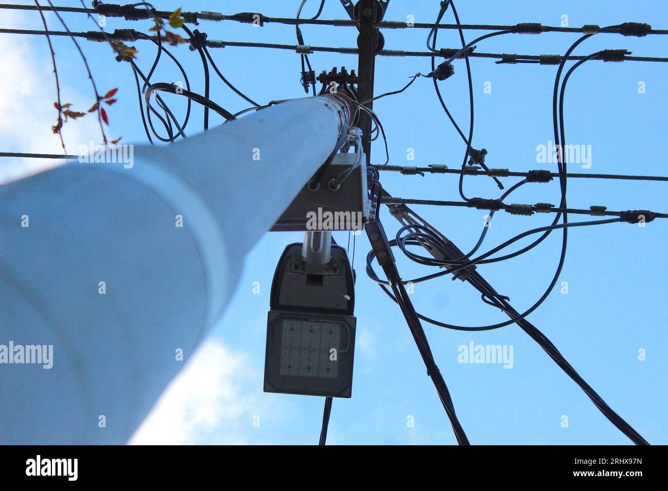 Ein Foto mit einem aufwärts gerichteten Winkel von einem Lampenstab und den daran angeschlossenen Elektrokabeln. Stockfoto