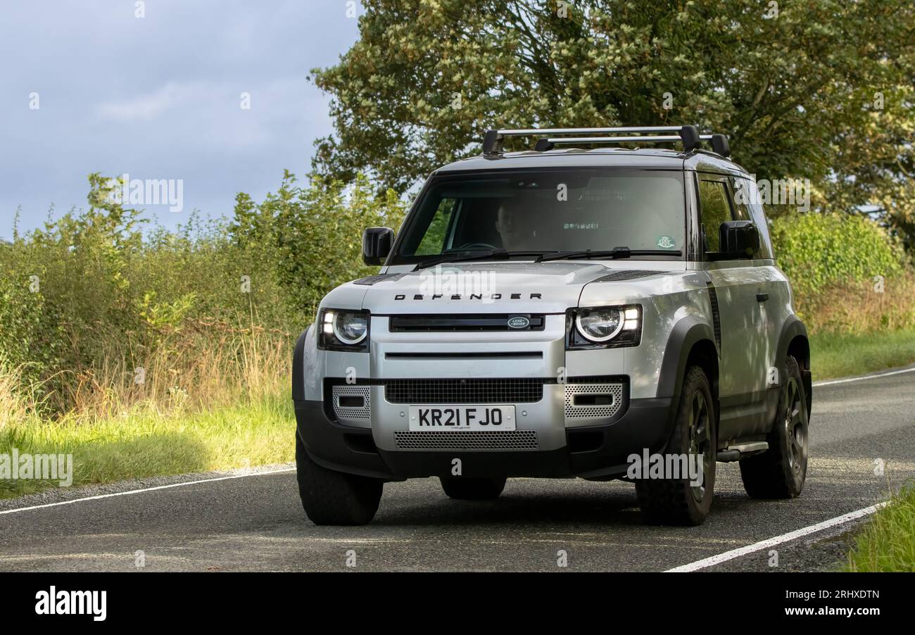 Woburn, Beds, Großbritannien - 19. August 2023: Silbernes Land Rover Defender-Auto 2021, das auf einer englischen Landstraße fährt. Stockfoto