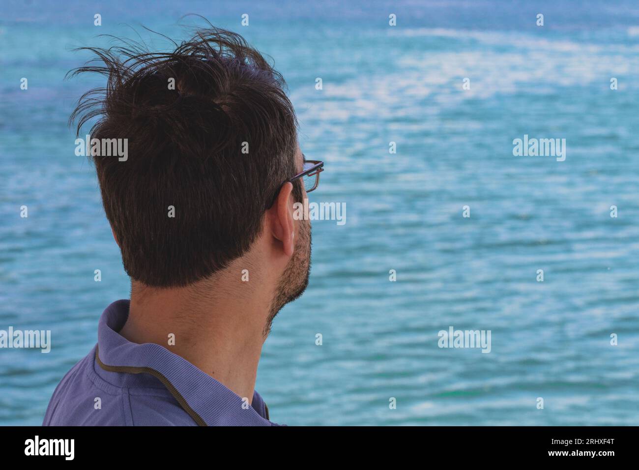 Blick von hinten auf einen Mann, der das Meer beobachtet. Leerzeichen kopieren Stockfoto
